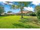 Manicured backyard featuring green lawn and mature trees surrounding the house at 477 Eagle Brook Ct, Debary, FL 32713
