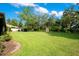 Lush backyard with a well-maintained lawn and mature trees, perfect for outdoor activities at 477 Eagle Brook Ct, Debary, FL 32713