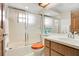 Bathroom featuring a combined tub and shower with glass door, white tiles, and a wood vanity at 477 Eagle Brook Ct, Debary, FL 32713