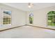Bright bedroom featuring white walls, carpet, a ceiling fan, and natural light from three windows at 477 Eagle Brook Ct, Debary, FL 32713