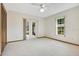 Bright bedroom with white carpet, window, closet and double doors leading to the outdoor space at 477 Eagle Brook Ct, Debary, FL 32713