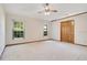 Bright bedroom featuring neutral carpet, dual windows, and a closet with wood doors at 477 Eagle Brook Ct, Debary, FL 32713