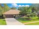 Charming single-story home with a well-manicured lawn, mature trees, and a paved driveway at 477 Eagle Brook Ct, Debary, FL 32713