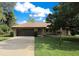 Charming single-story home with a well-manicured lawn, mature trees, and a paved driveway at 477 Eagle Brook Ct, Debary, FL 32713