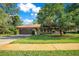 Charming single-story home with a well-manicured lawn, mature trees, and a paved driveway at 477 Eagle Brook Ct, Debary, FL 32713