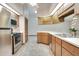 Well-lit kitchen featuring wood cabinets, stainless steel appliances, and a neutral countertop at 477 Eagle Brook Ct, Debary, FL 32713