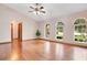 Spacious living room with vaulted ceiling, hardwood floors, and a ceiling fan, creating an airy feel at 477 Eagle Brook Ct, Debary, FL 32713