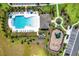 Aerial view of a community pool and playground, surrounded by lush landscaping and walkways at 4792 Vellacito Way, Davenport, FL 33897