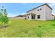 Spacious backyard with green lawn, privacy fence, and covered patio, great for outdoor entertaining at 4792 Vellacito Way, Davenport, FL 33897