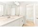 The spacious bathroom features double sinks, a large mirror, and a shower-tub at 4792 Vellacito Way, Davenport, FL 33897