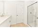 Bathroom featuring a glass-enclosed shower, white cabinets, and beige tile flooring at 4792 Vellacito Way, Davenport, FL 33897