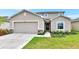 Charming two-story home featuring a well-manicured lawn, a stone-accented facade, and a two-car garage at 4792 Vellacito Way, Davenport, FL 33897