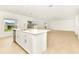 Open-concept kitchen with a central island flowing into a spacious, light-filled living area at 4792 Vellacito Way, Davenport, FL 33897