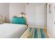 Cozy bedroom featuring a turquoise dresser, area rug, and white trim at 5 Riverwalk Dr # 601, New Smyrna Beach, FL 32169