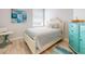 Bright bedroom with beach-themed decor, light blue walls, and wood flooring at 5 Riverwalk Dr # 601, New Smyrna Beach, FL 32169
