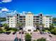 A scenic front view of a multi-story condo building with lush landscaping and ample parking at 5 Riverwalk Dr # 601, New Smyrna Beach, FL 32169