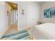 Hallway with tile floors leading to bedrooms with coastal decor at 5 Riverwalk Dr # 601, New Smyrna Beach, FL 32169