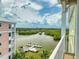 Balcony view overlooking a lush green waterway with boats docked and multi-story buildings in the distance at 5 Riverwalk Dr # 601, New Smyrna Beach, FL 32169