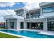 Modern architectural design showcasing clean lines, expansive windows, balcony, and a stunning pool with a spacious patio at 5023 Sawyer Cove Way, Windermere, FL 34786