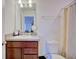 Bright bathroom featuring a vanity and a toilet next to a shower with a striped curtain at 5164 Chickadee St, St Cloud, FL 34771