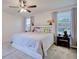 Bright bedroom featuring windows, neutral walls, ceiling fan and a headboard with lights at 5164 Chickadee St, St Cloud, FL 34771