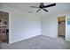 Carpeted bedroom with ceiling fan, and a glimpse into a closet at 5164 Chickadee St, St Cloud, FL 34771