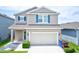 Charming two-story home featuring blue shutters, a two-car garage, and a well-maintained lawn at 5164 Chickadee St, St Cloud, FL 34771