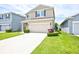 Attractive home featuring a two-car garage, a green lawn, and great curb appeal at 5164 Chickadee St, St Cloud, FL 34771