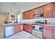Open kitchen featuring stainless steel appliances and dark wood cabinetry at 5164 Chickadee St, St Cloud, FL 34771