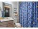 Charming bathroom featuring a patterned shower curtain, a vanity with modern fixtures, and a decorative wall sign at 5427 Orange Orchard Dr, Winter Garden, FL 34787