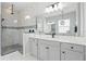 Bathroom featuring double vanities, a glass walk-in shower with dual shower heads, and stylish lighting at 5427 Orange Orchard Dr, Winter Garden, FL 34787