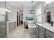 Bright bathroom featuring double vanities, a soaking tub, stylish light fixture, and a TV at 5427 Orange Orchard Dr, Winter Garden, FL 34787