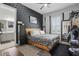 Modern bedroom with a striking black accent wall, wood bed frame, and natural light at 5427 Orange Orchard Dr, Winter Garden, FL 34787