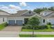 Beautiful home exterior with a brick driveway, two-car garage and manicured lawn at 5427 Orange Orchard Dr, Winter Garden, FL 34787