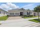 Well-kept single Gathering home boasts of two-car garage, manicured landscaping, and a brick paver driveway at 5427 Orange Orchard Dr, Winter Garden, FL 34787