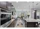 Well-appointed kitchen with a center island, stainless appliances, and adjacent dining area with bright light at 5427 Orange Orchard Dr, Winter Garden, FL 34787