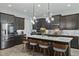 Modern kitchen with an island, pendant lighting, stainless steel appliances, and dark wood cabinets at 5427 Orange Orchard Dr, Winter Garden, FL 34787