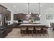 Modern kitchen with a large central island, pendant lighting, stainless steel appliances, and beautiful cabinets at 5427 Orange Orchard Dr, Winter Garden, FL 34787