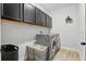 Convenient laundry room with modern washer, dryer, and overhead cabinets for storage at 5427 Orange Orchard Dr, Winter Garden, FL 34787