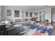 Bright living room featuring modern gray sectional sofa, colorful rug and unique art pieces, plus a desk area at 5427 Orange Orchard Dr, Winter Garden, FL 34787
