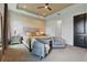 Spacious primary bedroom featuring neutral tones, tray ceilings, accent chairs, and an inviting king bed at 5427 Orange Orchard Dr, Winter Garden, FL 34787