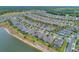Wide aerial view of a neighborhood with single-Gathering homes, green spaces, and a tranquil lake at 553 Adenmore Ter, Deland, FL 32724