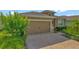A paved driveway leads to a two-car garage door with a well-maintained landscape at 553 Adenmore Ter, Deland, FL 32724