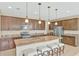 Modern kitchen features a large island, granite countertops, stainless steel appliances, and brown cabinetry at 553 Adenmore Ter, Deland, FL 32724