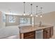 An open-concept living room showcases a granite countertop kitchen island and sliding glass doors at 553 Adenmore Ter, Deland, FL 32724