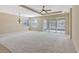 A spacious living room featuring neutral walls, carpet, and sliding door to backyard at 553 Adenmore Ter, Deland, FL 32724