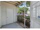 Enclosed patio with a screen and a white door, offering an outdoor retreat with a view of the parking area at 6100 Westgate Dr # 101, Orlando, FL 32835
