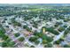 Scenic aerial view of a neighborhood with lush landscaping and mature trees providing ample shade at 618 Meadow Park Dr, Minneola, FL 34715