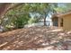Spacious backyard featuring mature trees, lush landscaping, and a white privacy fence at 618 Meadow Park Dr, Minneola, FL 34715