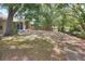 Large backyard with partial view of the home, trees, landscaping, and a wooden privacy fence at 618 Meadow Park Dr, Minneola, FL 34715